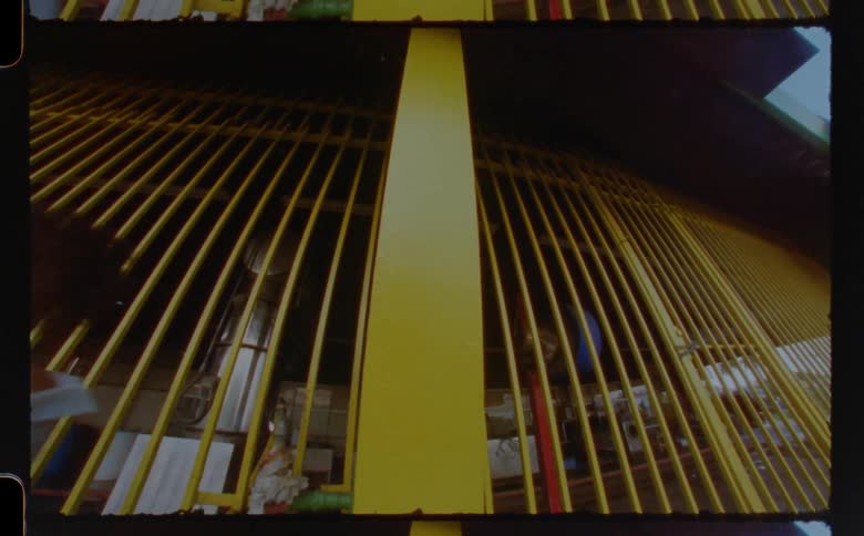 A woman standing against a yellow pole attached to a building as she looks sad and walks away