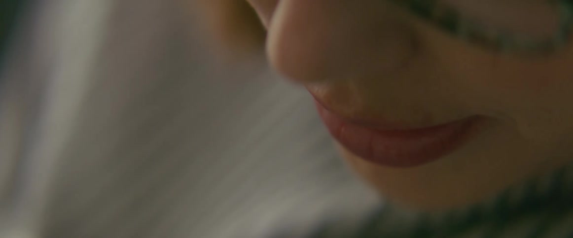Woman with glasses and white shirt looks down at baby smiling