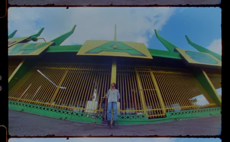 A woman is standing in front of the yellow fence