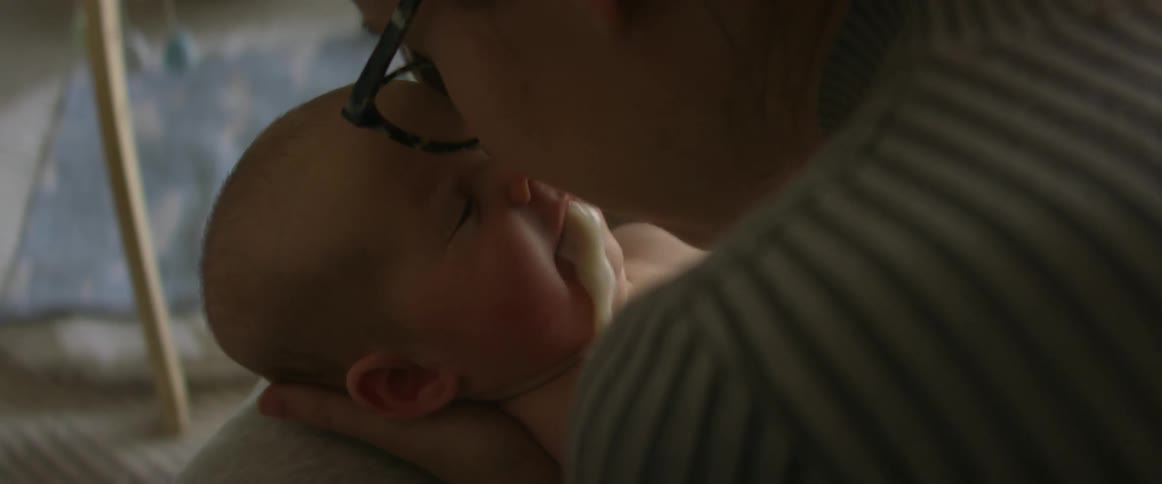 Baby vomiting as mother leans forward for a kiss