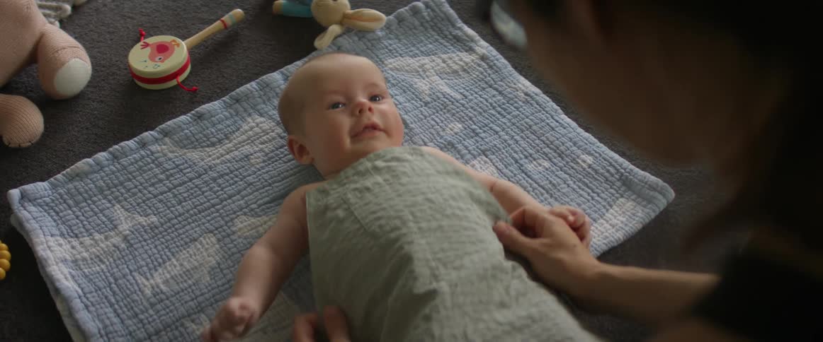 Mother rubs a newborn baby with a towel at home