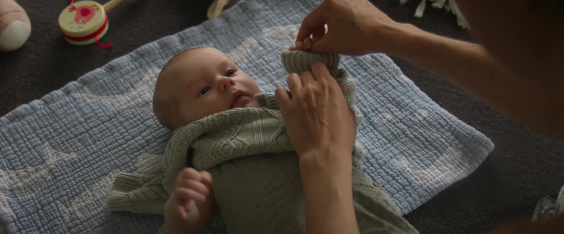 Mother dresses newborn baby