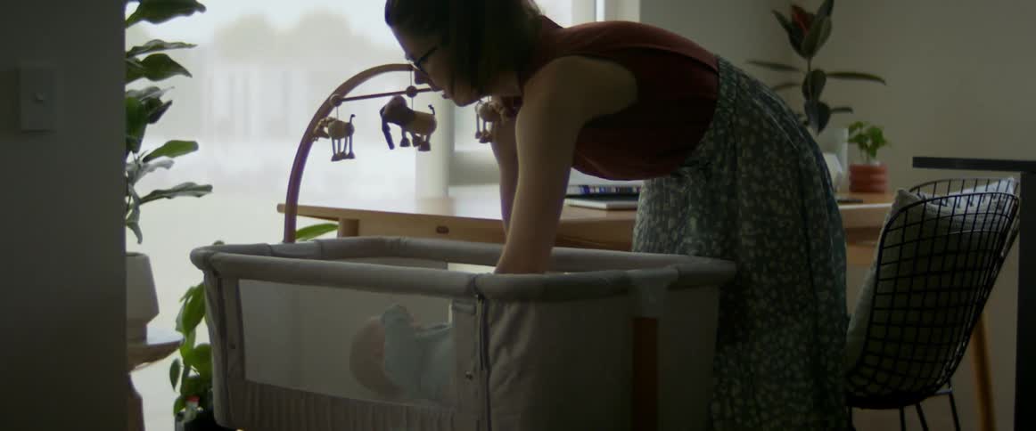Mother placing newborn in bassinet for a nap