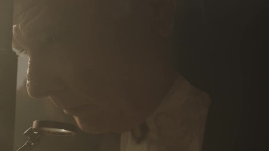 A man is looking through a microsocope