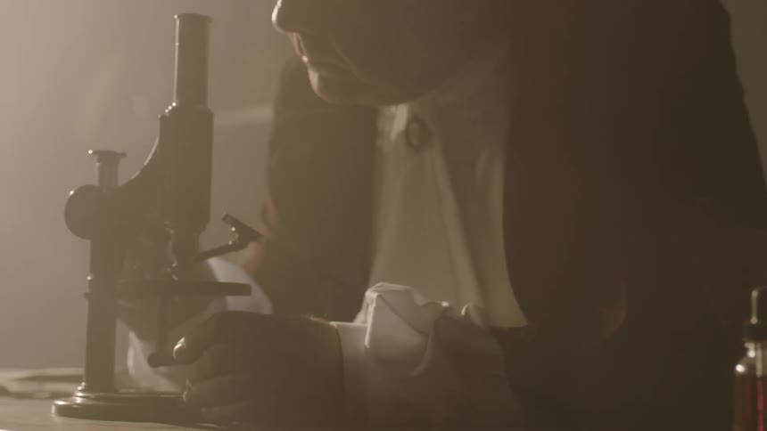 A man adjusts his microscope