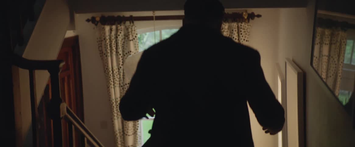 A man runs down a hallway and steps in his house