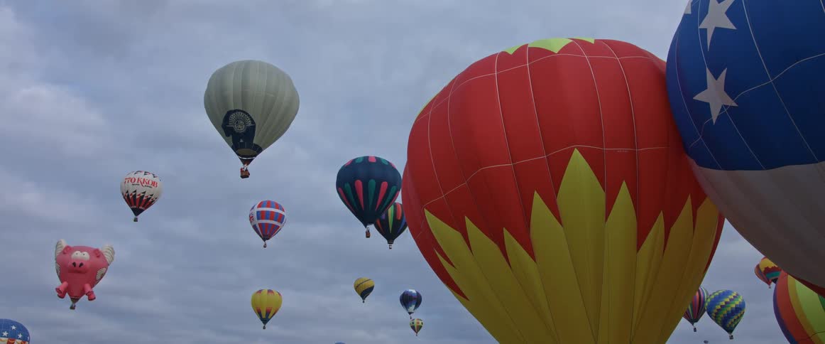 Multiple hot air balloons floating in the air