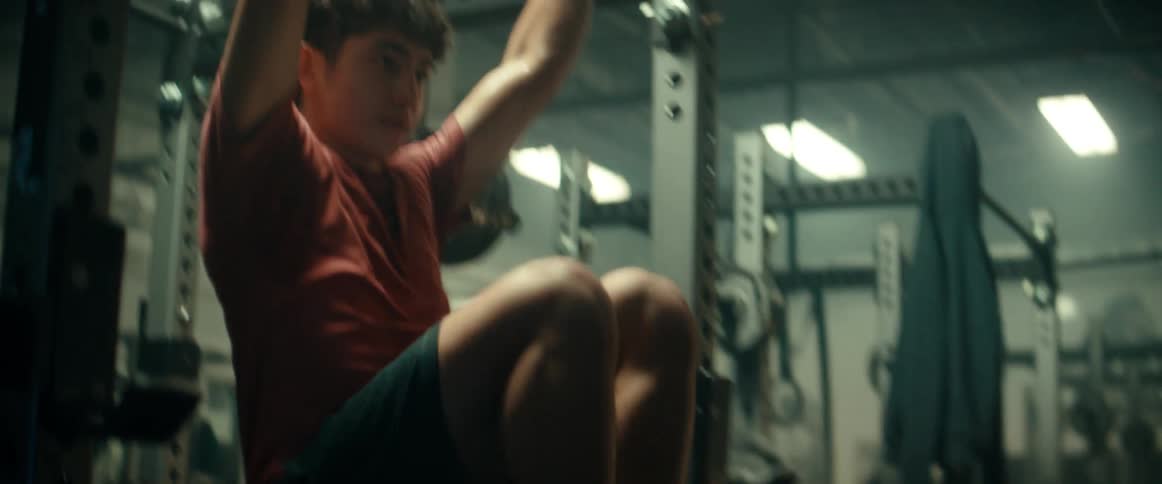 A man does hanging sit ups on a pull up bar at the gym