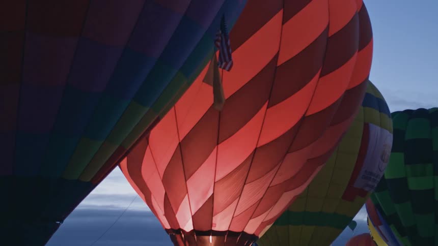 A flame is ignited in a hot air balloon docked with other hot air balloons