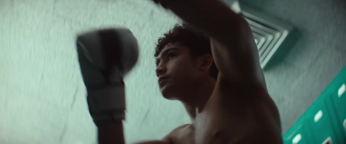 A man practices boxing moves in a locker room
