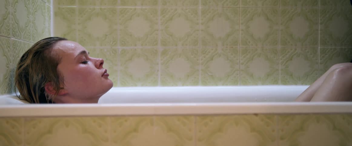 Woman with fair hair having a bath in the bathroom