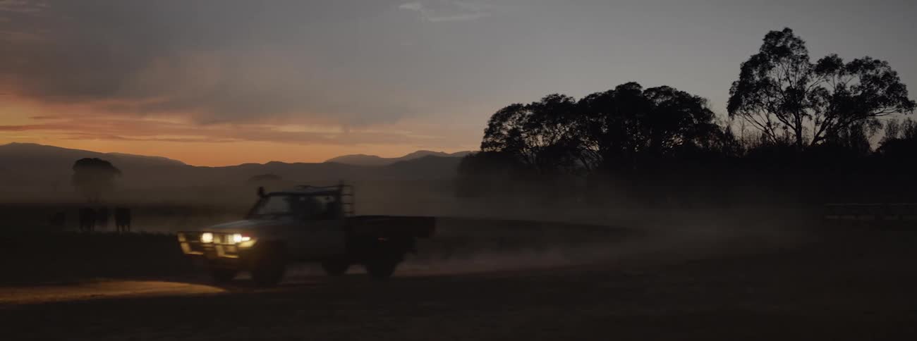 A pick up truck drives on the field