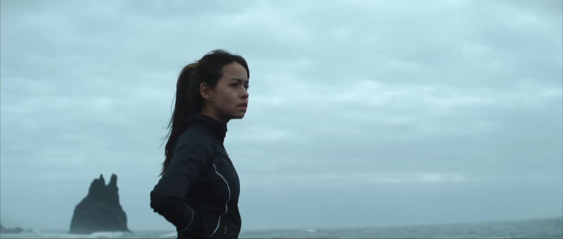 A woman looks out over the ocean