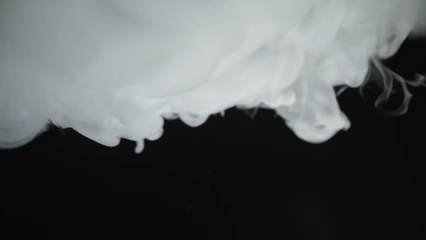Billowing white smoke in front of a black background