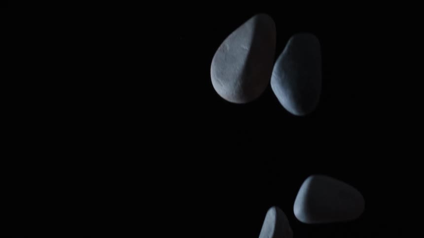 Gray smooth rocks flying through the air
