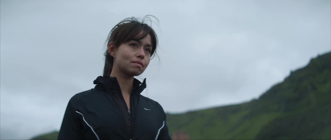 A woman is posing by the mountain