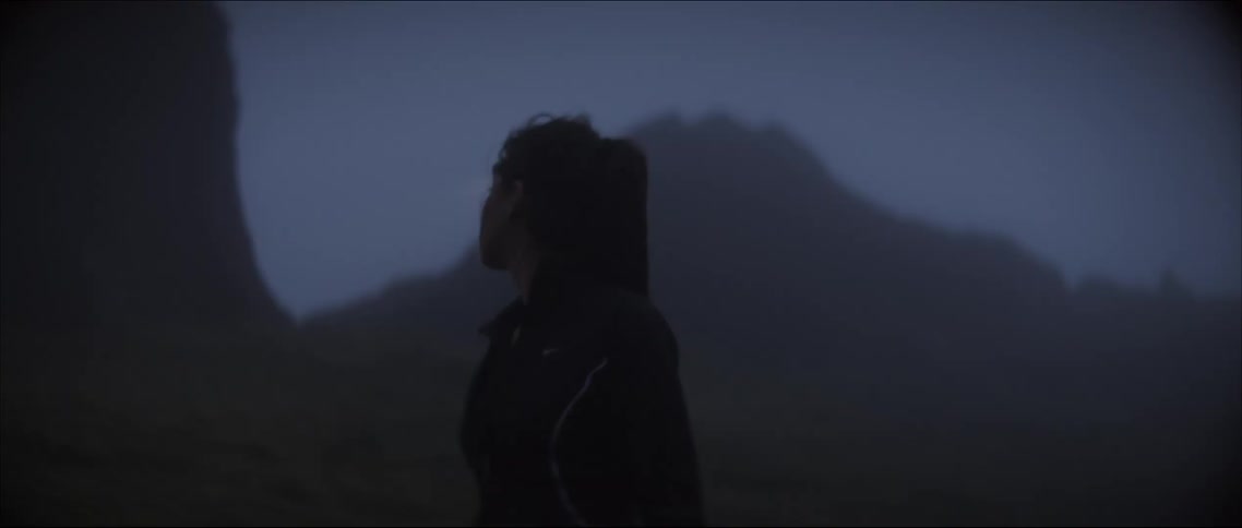 A woman with a headlamp looking lost and scared while hiking in nature at n ight