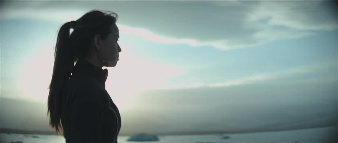 A woman standing looking out over the ocean