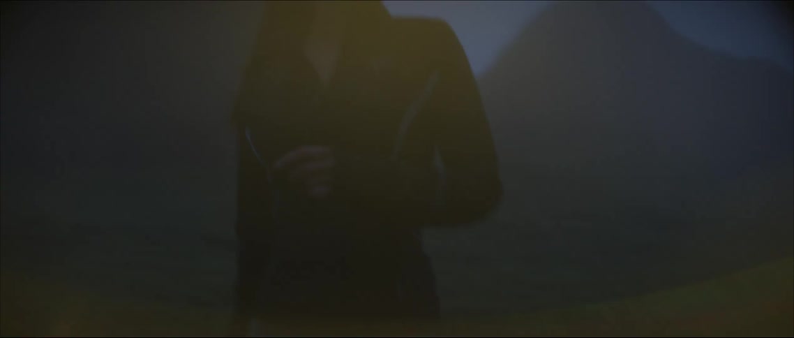 A woman wearing a headlamp runs alone along a trail while wearing a headlamp
