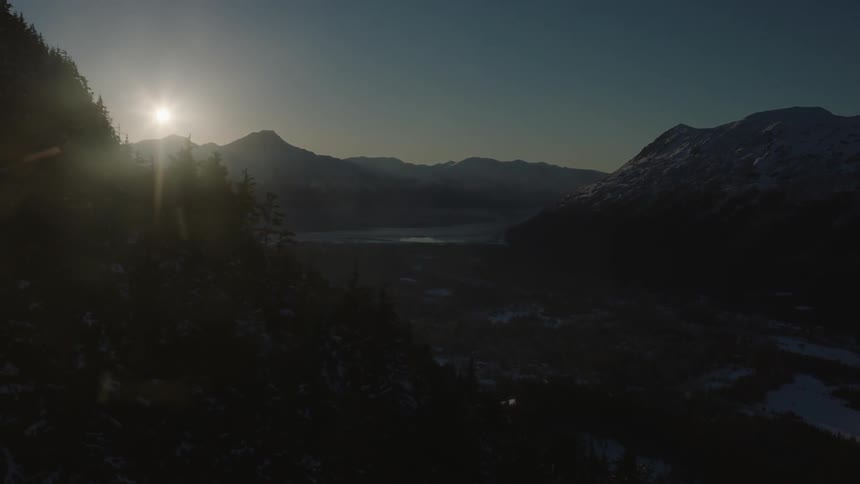 The sun shines over mountains
