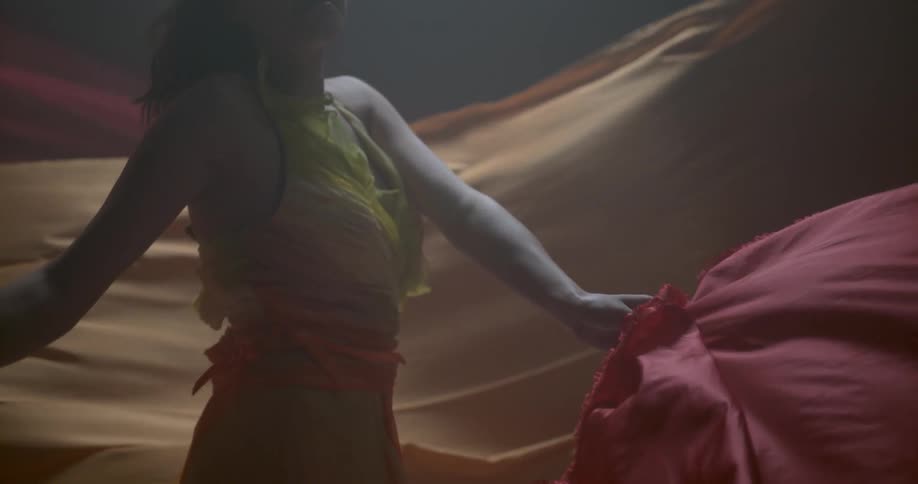 Woman twirls a large red sheet around
