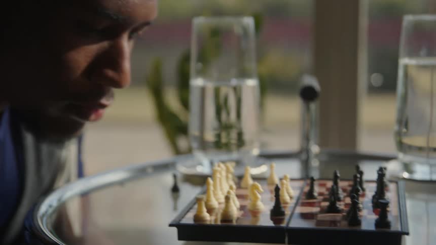 A man looks down at a chess board