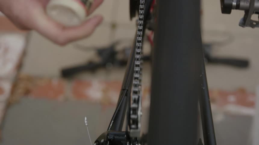 A man applies oil to his bicycle chain