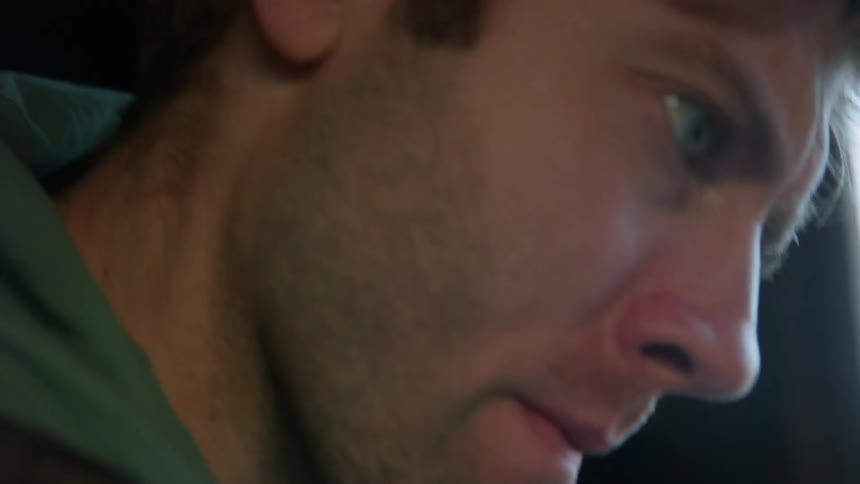Man concentrates while working inside near window