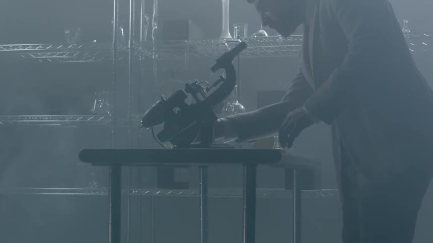 A man adjusts a microscope