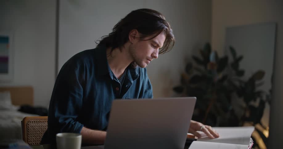 A man is sitting at his desk and reading