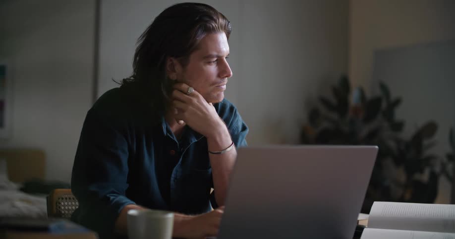 A man is deep in thought and sitting at his desk