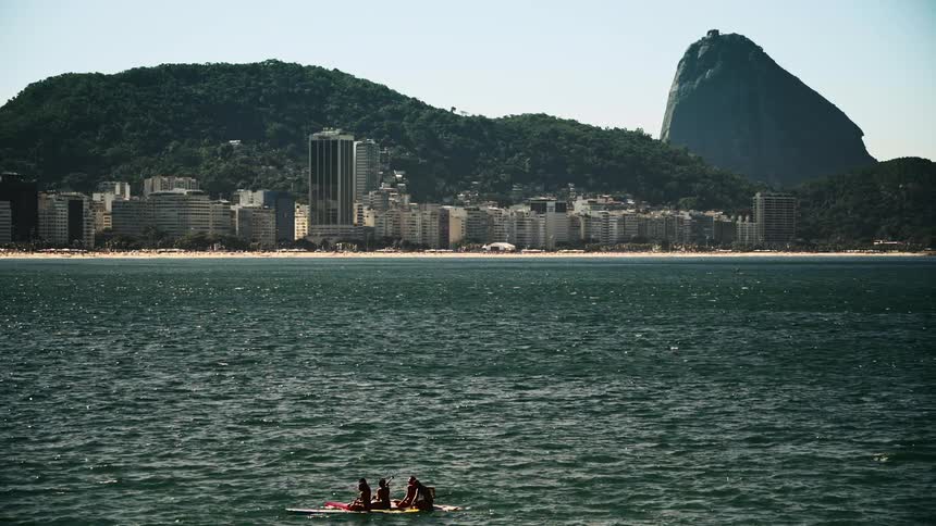 People are rowing in the water near the city
