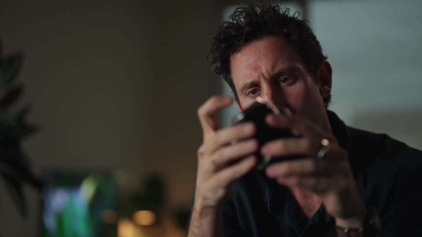 A man is looking through a camera lens