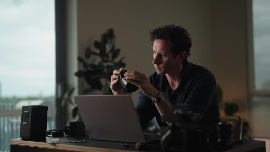 A man is sitting at his computer desk indoors