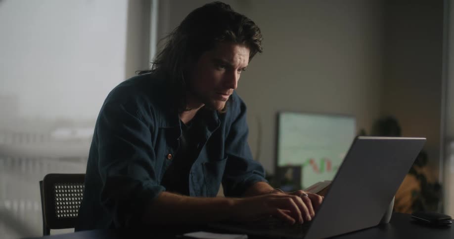 A man is typing on his laptop