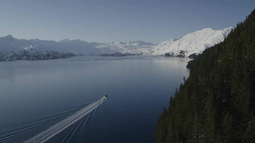 A boat sails towards a mountain below