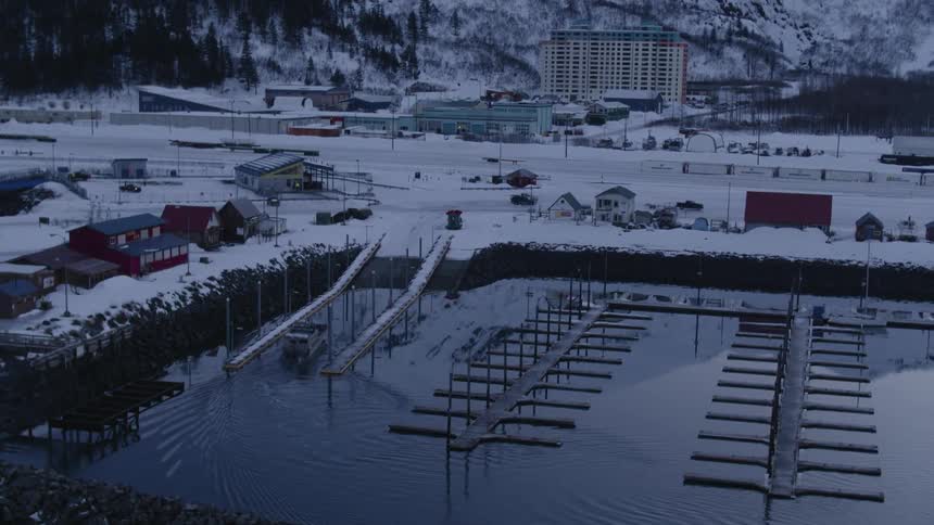 A boat pulls into a snow covered dock