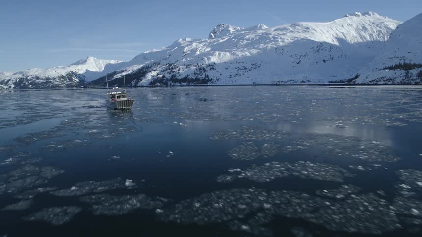 A boat is sailing in the ice filled lake