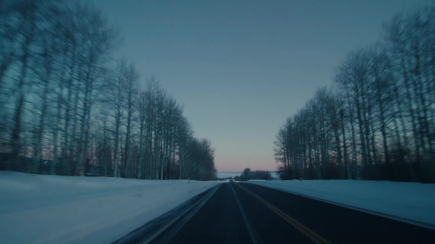 A highway runs through snow covered fields