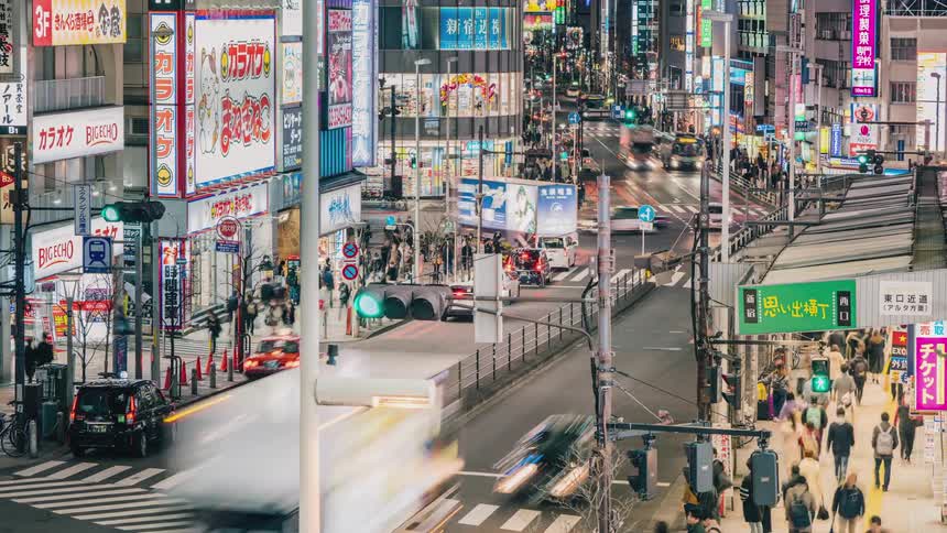 Vehicles and traffic pass through a bustling city intersection