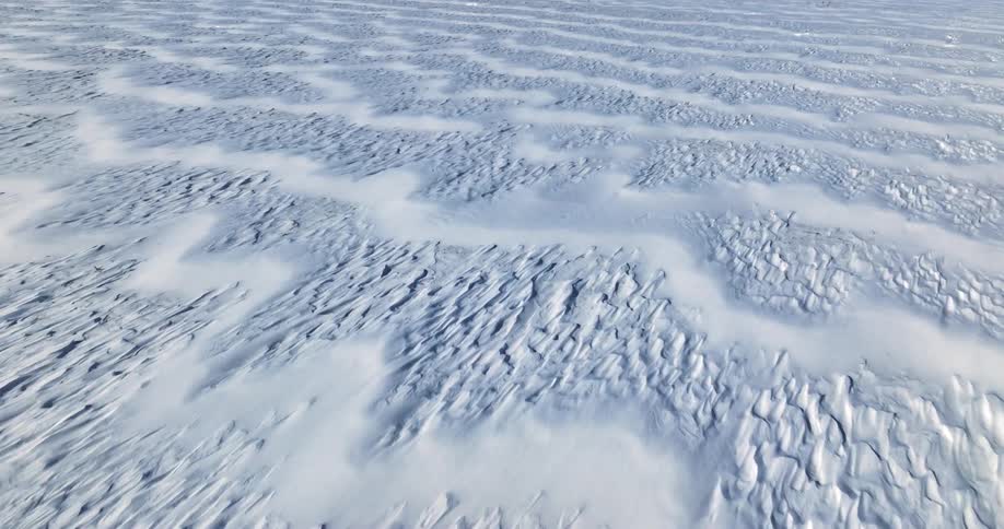 Ice forms patterns in a snow covered field