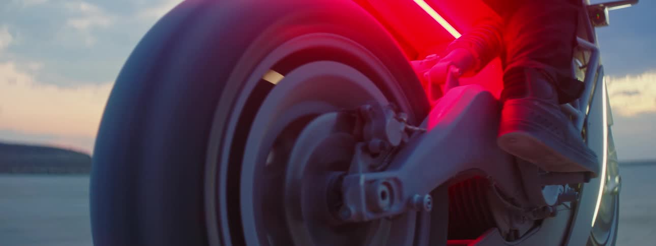 Close up view of a person riding a motorcycle at dusk