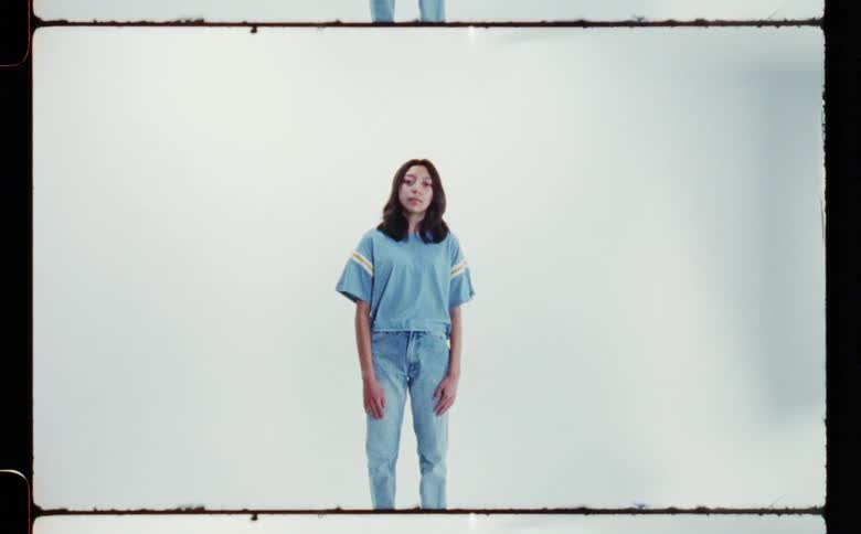 A girl is posing wearing a tshirt and jeans