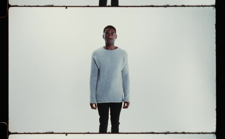A man is standing still wearing clothes