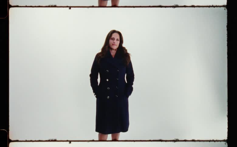 A woman is posing in a coat