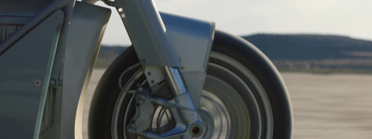 The front tire of a motorcycle traveling through the desert