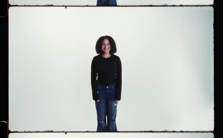 A girl is smiling as she poses