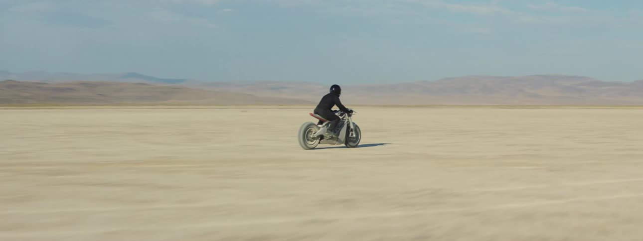 The motorcycle speeds through the desert