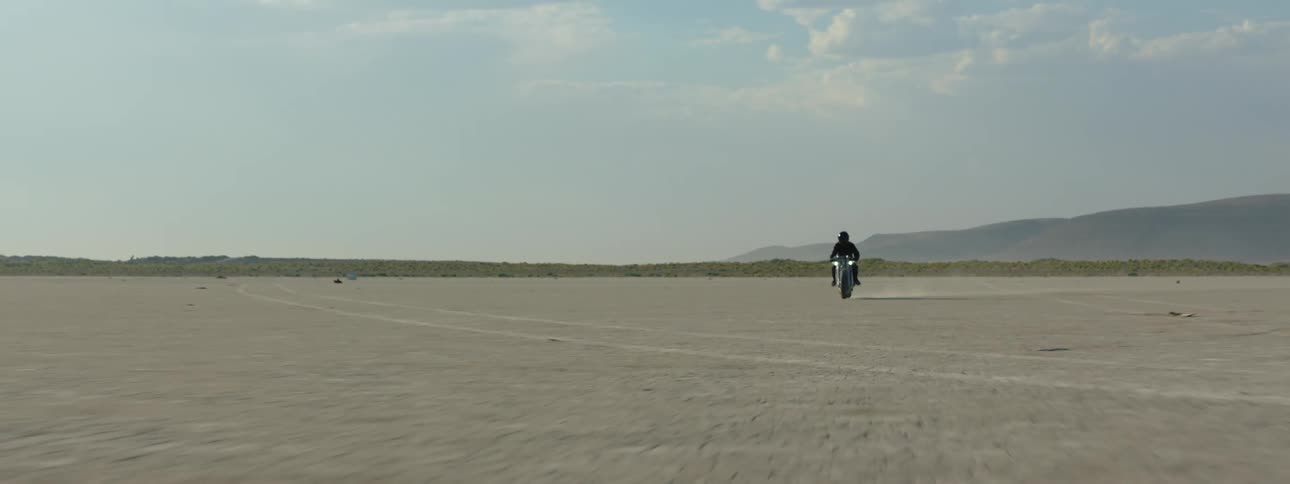 The motorcycle speeds through the desert