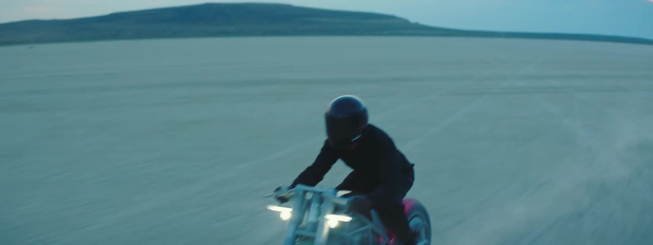 A motorcylist speeds through the desert